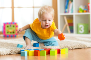 child toddler playing wooden toys at home or kindergarten